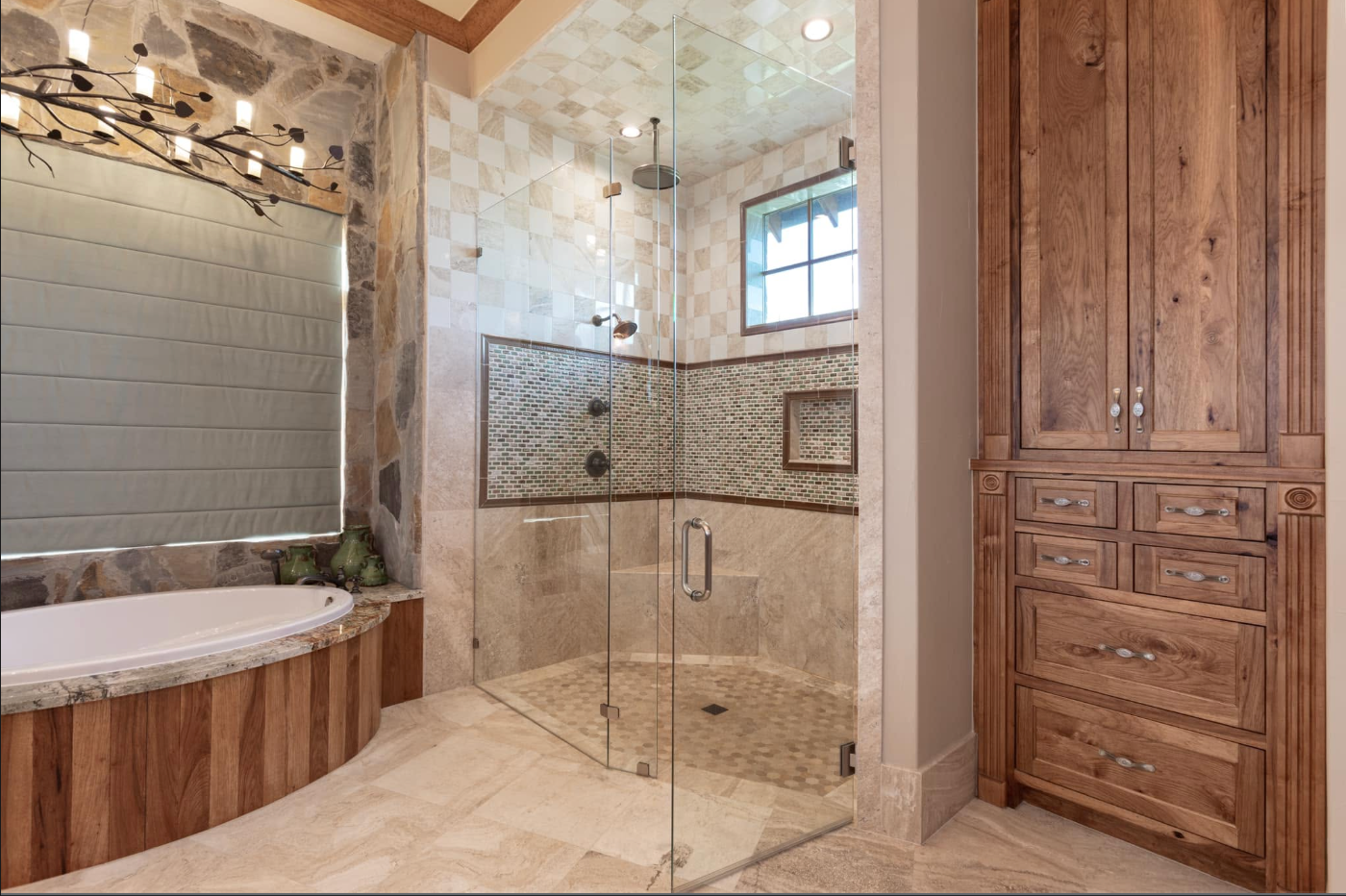 Principal bathroom with wood cabinetry, soaking tub, and glass shower