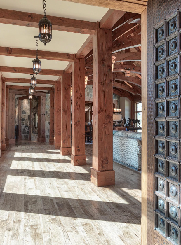 Sunlit gallery hall with carved door and hanging lanterns