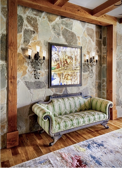 Antique green settee against a natural stone wall